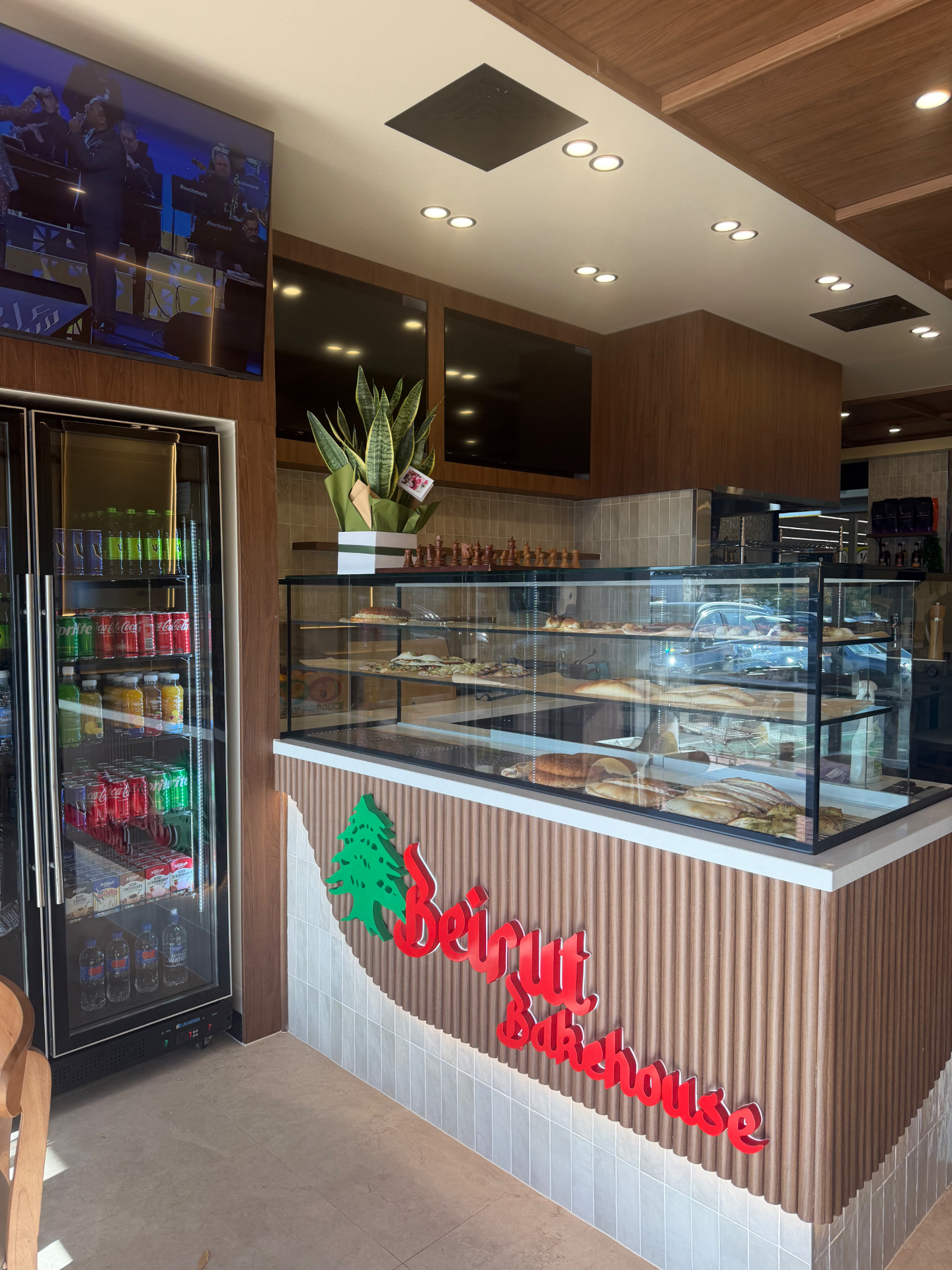 Interior counter at Beirut Bakehouse showing the branded counter front and drinks fridge