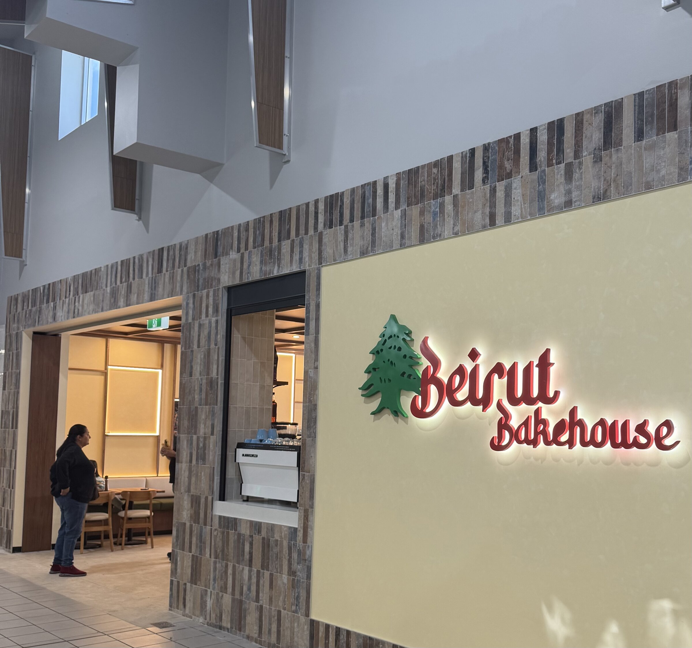 Exterior storefront of Beirut Bakehouse with illuminated signage on the cream wall
