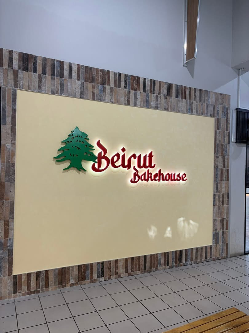 Illuminated Beirut Bakehouse signage with the Lebanese cedar on the cream feature wall